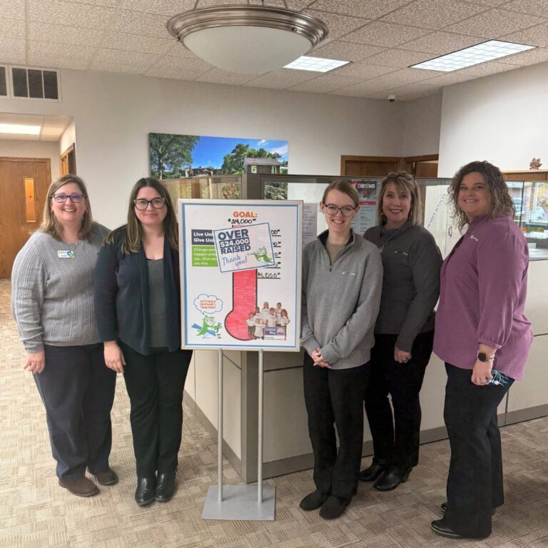 DoverPhila employees standing in front of United Way campaign poster.